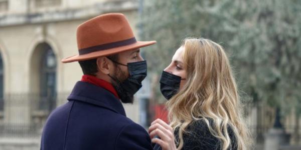 Pareja de enamorados con mascarilla por la calle