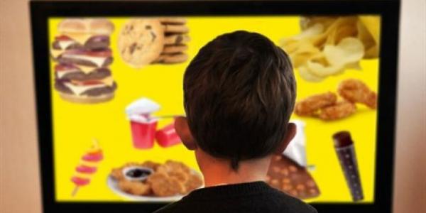 Imagen de archivo de un niño contemplando un menú de productos no saludables.EP