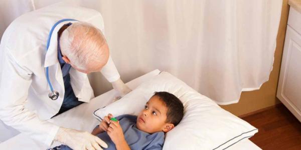 Doctor atendiendo a niño con dolor abdominal