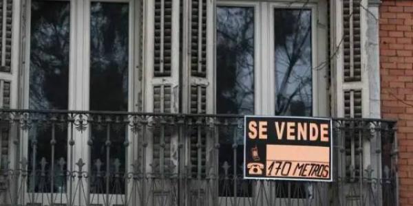 El cartel de "Se vende" en el balcón de una vivienda
