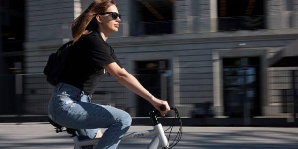 Chica en bicicleta eléctrica por la ciudad
