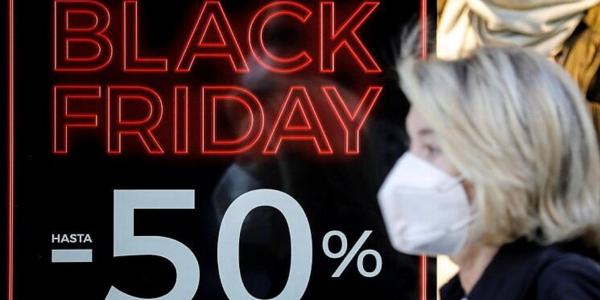 Persona con mascarilla sobre cartel de Black Friday