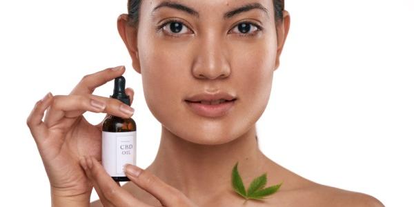 Rostro de mujer utilizando un producto de cosmética con CBD
