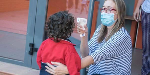 Una profesora toma la temperatura a una alumna del colegio Tajamar 