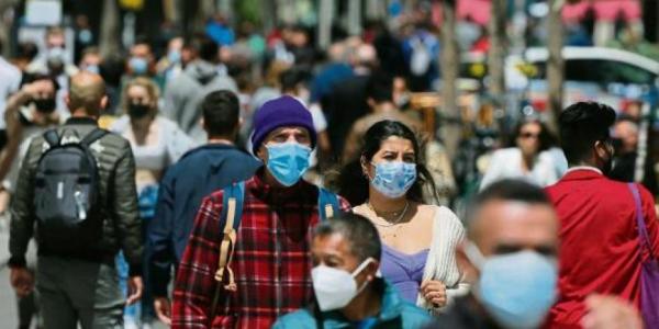 Personas por la calle con mascarilla 