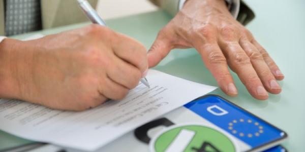 Persona firmando un contrato de compraventa