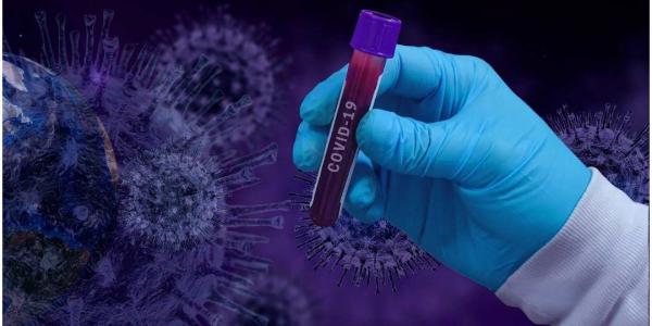 Mano de científico sujetando una muestra de sangre infectada con coronavirus