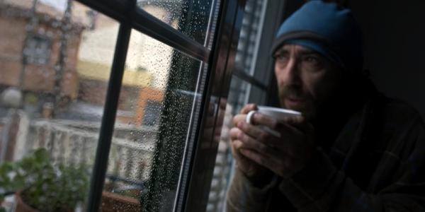 Persona tomando caldo caliente al lado de una ventana (Laura Guerrero / La Vanguardia)