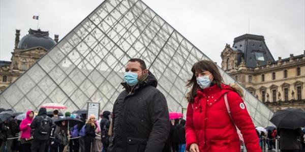 Visitantes con mascarillas en la puerta del Museo del Louvre en París. Foto: EFE