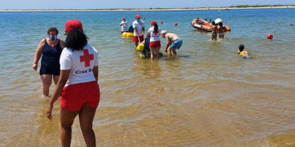 Varios voluntarios de Cruz Roja Huelva en una jornada de playa con discapacitados