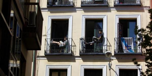 Varios inquilinos toman el sol en sus balcones durante el confinamiento domiciliario por el coronavirus.