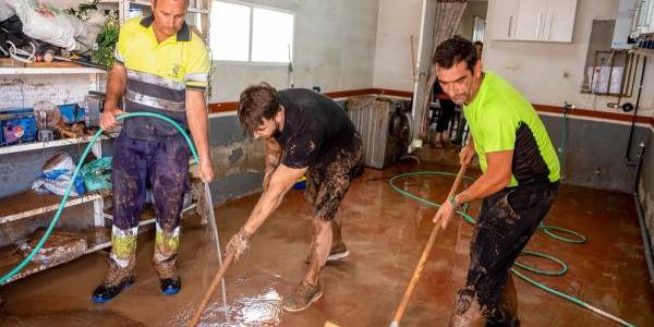 Personas limpiando una casa por efectos de la DANA