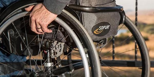 Un señor mueve su silla de ruedas