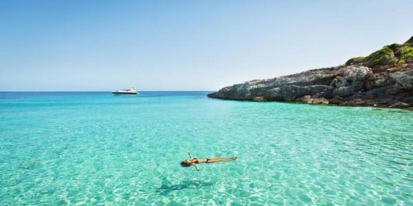 Chica bañándose en una playa de Menorca
