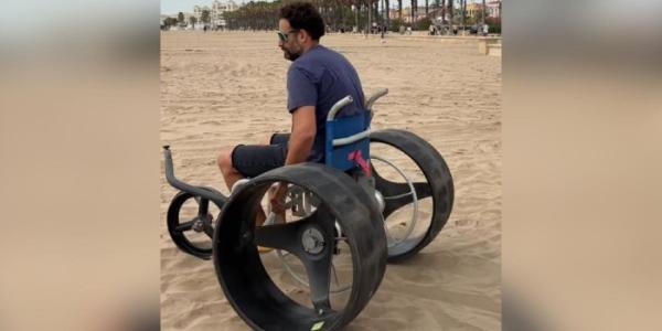 Cesar con su silla de ruedas en la playa