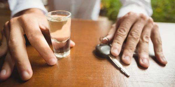 Vaso de alcohol al lado de unas llaves de coche
