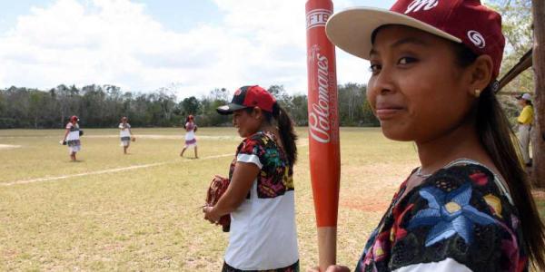 Las jugadoras de "Las Diablillas de Hondzonot" esperan su turno al bate ante las "Guerreras de Piste", en Hondzonot, municipalidad de Tulum, estado de Quintana Roo, México, en abril de 2021. - Foto: AFP