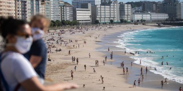 Decenas de personas, en la playa de Riazor, en A Coruña. En vídeo, tres de cada cuatro españoles estarán el lunes en fase 3. FOTO: ÓSCAR CORRAL 