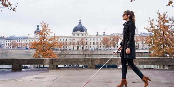 Una mujer con discapacidad visual paseando por una ciudad