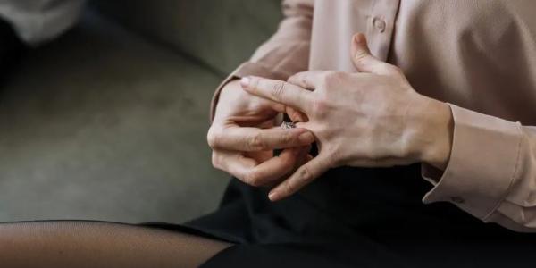 Mujer quitándose un anillo de casada