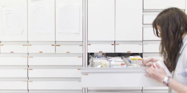 Una trabajadora busca fármacos en una farmacia. 