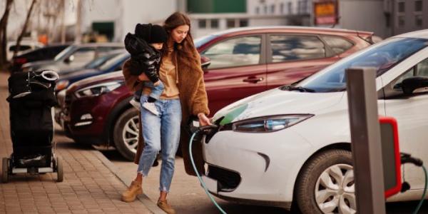 Mujer cargando vehículo eléctrico 