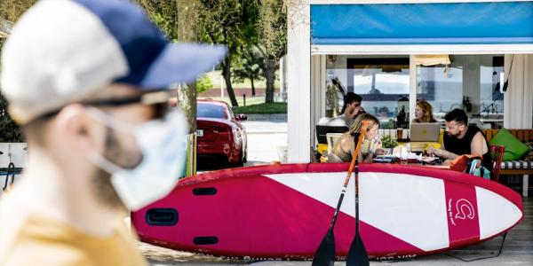 Un hombre con mascarilla pasea ante un chiringuito (Xavier Cervera) / La Vanguardia