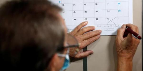 Un señor marcando una fecha en el calendario