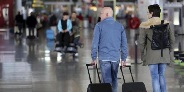 Dos personas con maletas caminan por el Aeropuerto de Málaga. CARLOS DÍAZ para El Mundo