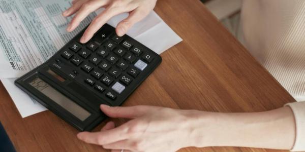 Mujer con calculadora haciendo una factura