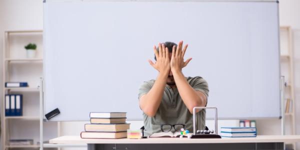 Un profesor descansa en su pupitre 