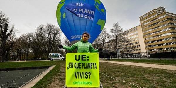Activista de Greenpeace despliega una pancarta con el lema 'UE: ¿en qué planeta vivís?', delante del globo aerostático