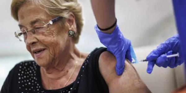 Una anciana vacunándose de la gripe. 