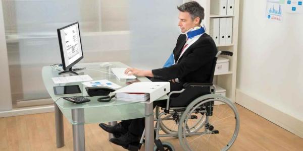 Hombre en silla de ruedas trabaja frente a su escritorio