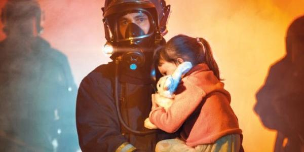 Bombero rescatando de incendios a una menor