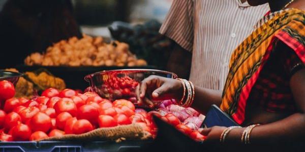 Mujer comprando tomates en el mercado