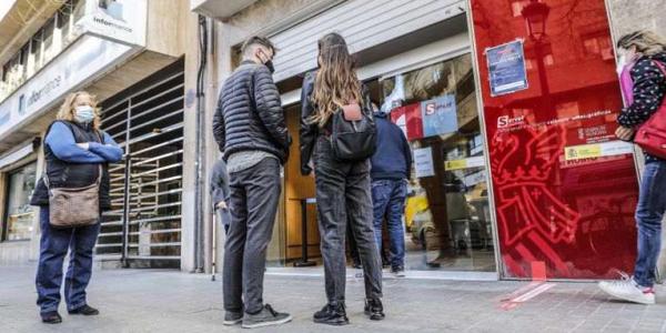 Varias personas hacen cola ante la puerta de oficina de empleo en València. ROBER SOLSONA / EUROPA PRESS