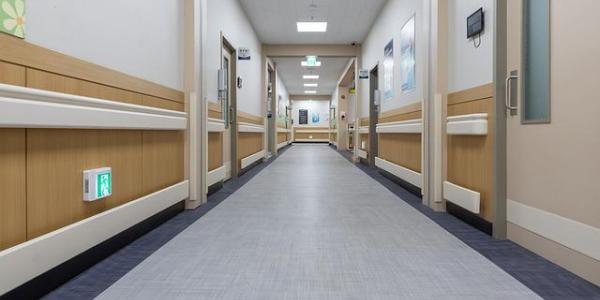 El pasillo de un hospital con habitaciones 