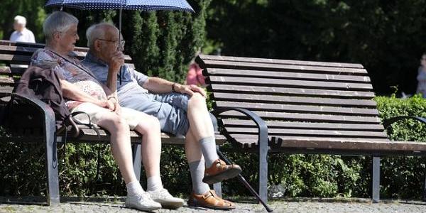 Dos personas mayores sentadas en un banco
