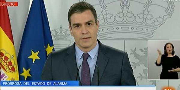 Pedro Sánchez en televisión con la intérprete de lengua de signos a la derecha 