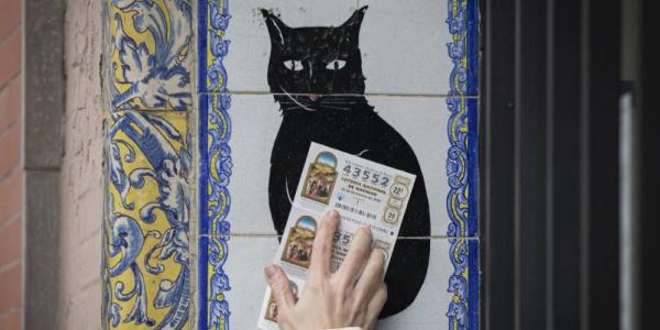 Una persona pasa un décimo de Lotería por azulejo de 'El gato negro' 