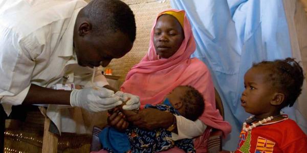 Un técnico de laboratorio extrae una muestra de sangre de un niño para detectar la malaria