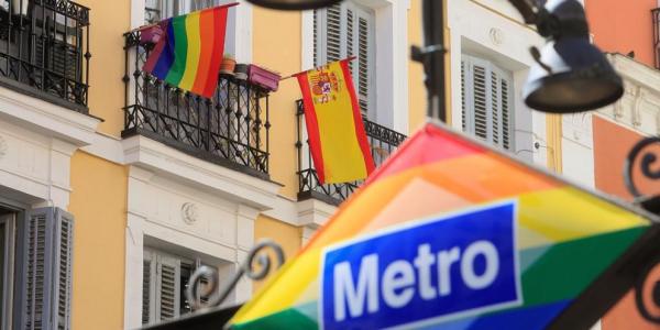Banderas arcoíris y española decoran un balcón de la madrileña plaza de Chueca con motivo de las celebraciones del Orgullo 