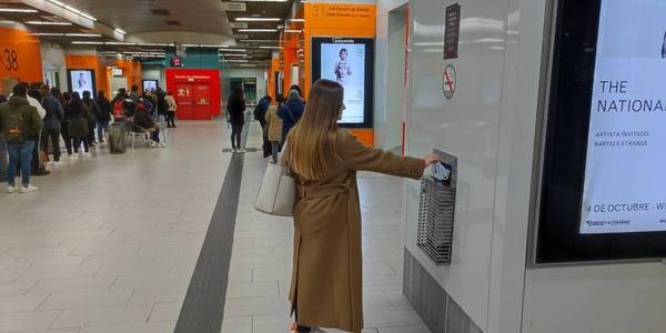 Una chica tira su mascarilla antes de subirse a su autobús.