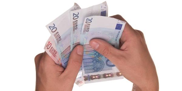 Manos de una persona contando billetes de 20 euros