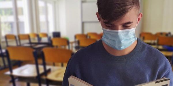 Chico en un aula con mascarilla