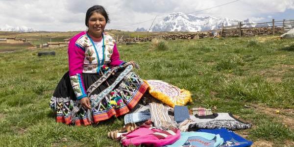 La presidenta de Atiptalla con las prendas elaboradas con lana de alpaca