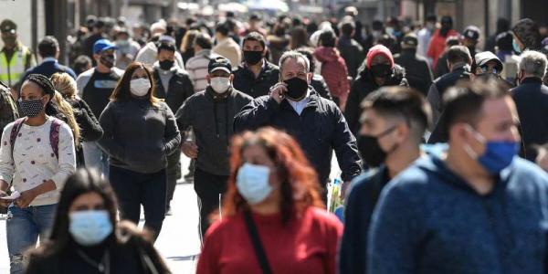 Gente pasea por la calle con mascarilla