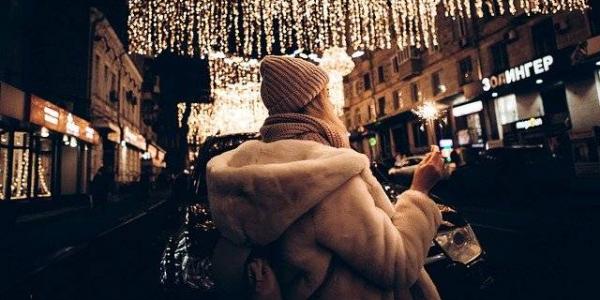 Chica por la calle iluminada con luces de Navidad