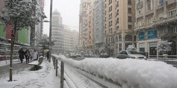 Nevada en el centro de Madrid, las personas pasean muy abrigadas  